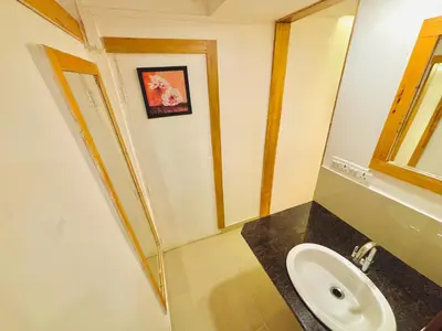 a bathroom with a sink and a mirror at RIO ROOMS Medical College in Kozhikode