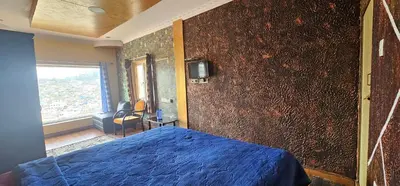 a bedroom with a blue bed and a wall at OOTY STAY AWHILE in Ooty