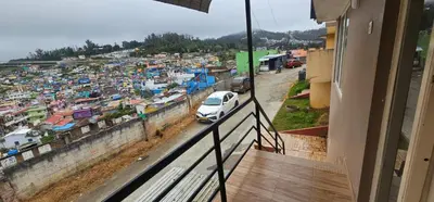 a view from a balcony of a city with a car at OOTY STAY AWHILE in Ooty