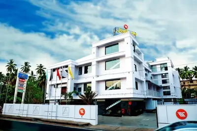 a white building with a sign on top of it at Kallada Mamatha Motels in Kunnamkulam