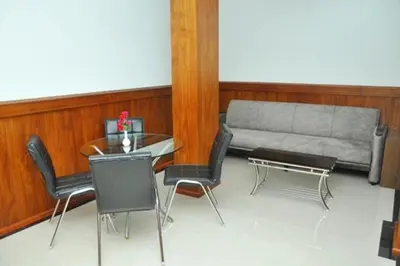 a living room with a table and chairs and a couch at Kallada Mamatha Motels in Kunnamkulam