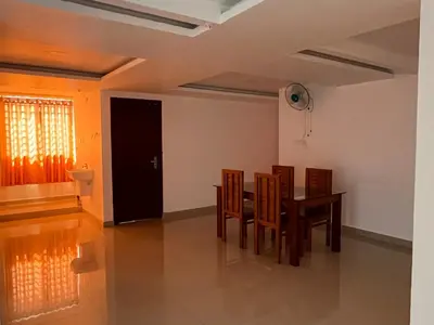 a dining room with a table and chairs at Plaza Residency in Badagara