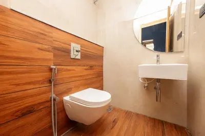 a bathroom with a toilet and a sink and a mirror at THE CONTINENTAL INN & SUITES in Mysore