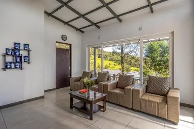 a living room with couches and a table at Wattle Grove Resort in Kotagiri