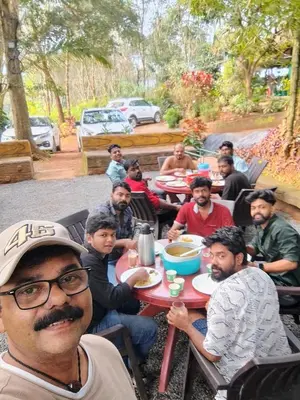 a group of men sitting at a table eating food at Verdant Hillock in Wayanad