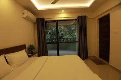 a bedroom with a bed and a large window at VVP Service Apartments in Nedumbassery