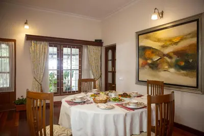 a dining room with a white table with food on it at Marlihill Bungalow - A CGH Earth SAHA Experience in Ooty