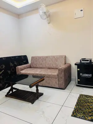 a living room with a couch and a table at 1BhK in Sultan Bathery