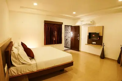 a bedroom with a bed and a tv in it at GREEN MOUNT RESORTS in Malaiyāndipattanam