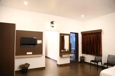 a room with a bed and a tv on a wall at GREEN MOUNT RESORTS in Malaiyāndipattanam