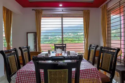 a dining room with a table and chairs and a window at Green Premium Villa Ooty by Lexstays in Ooty