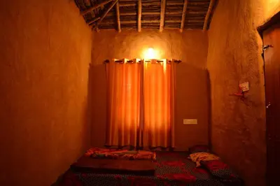 a bedroom with an orange curtain in a room at Cosmic Mud House Kanthalloor in Kanthalloor