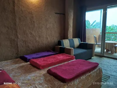 a living room with a couch and a chair at Cosmic Mud House Kanthalloor in Kanthalloor