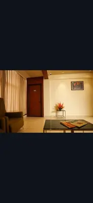 a living room with a table and a couch at Hotel Harigovindas Express Mysore in Mysore