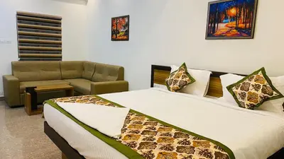 a bedroom with a large bed and a couch at POOJA inn in Guruvāyūr