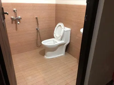 a bathroom with a toilet in a stall at POOJA inn in Guruvāyūr
