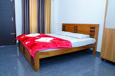 a bedroom with a bed with a red blanket on it at Coorg Lotus Villa in Madikeri