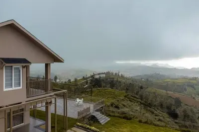 a dog standing on the balcony of a house at Nilgiri Valley Villa Ooty - a VKation Experience in Ooty
