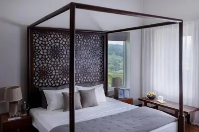 a bedroom with a canopy bed and a window at Nilgiri Valley Villa Ooty - a VKation Experience in Ooty
