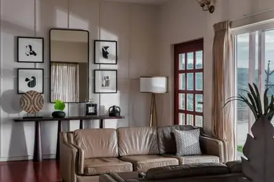 a living room with a couch and a mirror at Nilgiri Valley Villa Ooty - a VKation Experience in Ooty