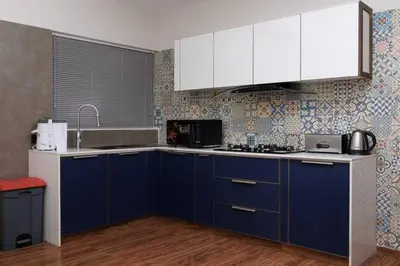 a kitchen with blue cabinets and white appliances at Nilgiri Valley Villa Ooty - a VKation Experience in Ooty