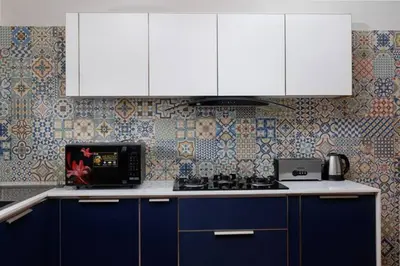 a kitchen with blue and white cabinets and a stove at Nilgiri Valley Villa Ooty - a VKation Experience in Ooty