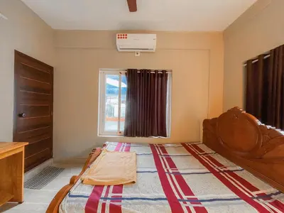 a small bedroom with a bed and a window at MB Arcade in Tellicherry