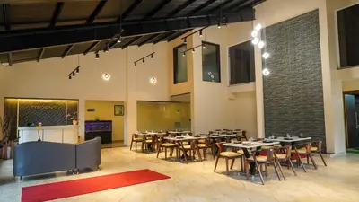 a restaurant with tables and chairs in a room at Trident in Ooty