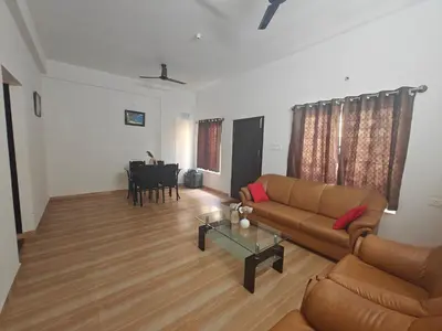 a living room with a couch and a table at Urban Nest Residence in Mysore