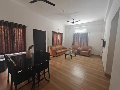 a living room with a piano and a couch at Urban Nest Residence in Mysore