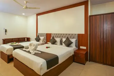 a bedroom with two beds with a stuffed animal sitting on the bed at Royal Plaza City in Kozhikode