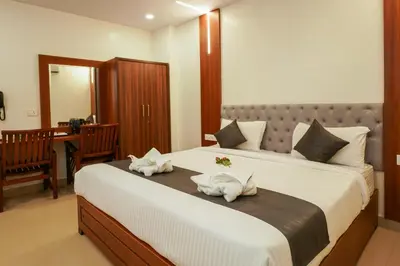 a bedroom with a large bed with two pigs on it at Royal Plaza City in Kozhikode