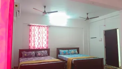 a room with two beds and a ceiling fan at AYYAN RESIDENCY in Alāndurai
