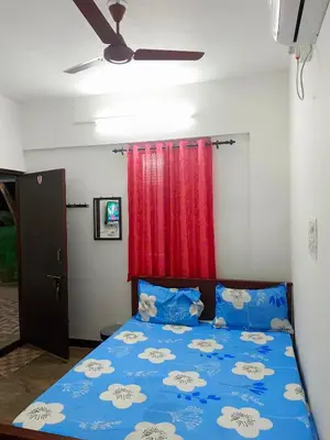 a bedroom with a blue bed with a red curtain at AYYAN RESIDENCY in Alāndurai