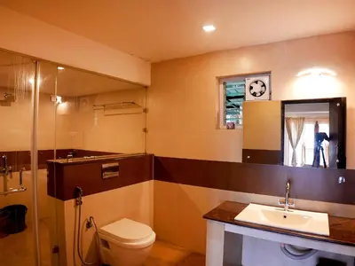 a bathroom with a toilet and a sink and a mirror at Vista Sunrise Resort Ooty Dodabetta in Ooty