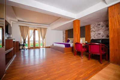 a living room with a bed and a table and chairs at Vista Sunrise Resort Ooty Dodabetta in Ooty