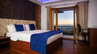 a bedroom with a bed with a view of the ocean at Vista Sunrise Resort Ooty Dodabetta in Ooty