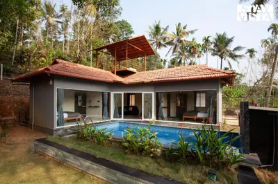 a villa with a swimming pool and a house at StayVista at Palm Tree Homes with Complimentary Breakfast, BBQ Grill and Pet-Friendly Home in Wayanad