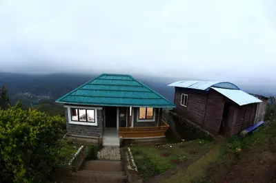 two small houses on top of a hill at Vrindhavan Mist City Resorts in Kanthalloor