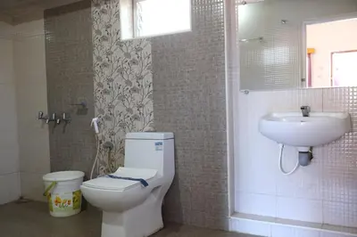 a bathroom with a toilet and a sink at Hotel Sri Balaji in Ooty
