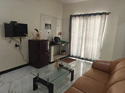 a living room with a couch and a glass table at The Whispering Willows in Mysore