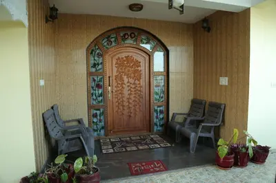 a lobby with a door with two chairs and plants at Madhu Manish Homestay and Rooms in Coonoor