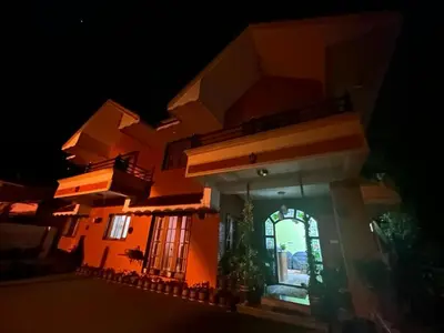 a house at night with the lights on at Madhu Manish Homestay and Rooms in Coonoor