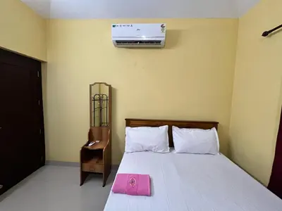 a bedroom with a bed with a pink towel on it at Manasam Homes Near To IIM & NIT - kOZHIKODE in Kunnamangalam