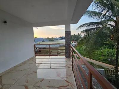 a balcony with a view of a palm tree at Centre Home Homestay Wayanad in Kalpetta