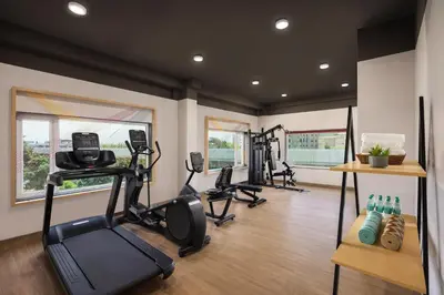a gym with treadmills and exercise equipment in a room at Ginger Coimbatore Airport , Avinashi Road in Coimbatore