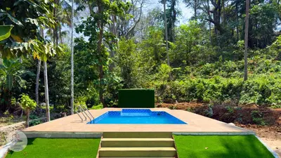 a swimming pool in the middle of a garden at Peechi Green Valley in Pattikad