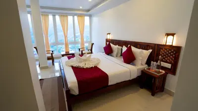 a bedroom with a large bed with red and white pillows at Carmel Top Munnar in Munnar