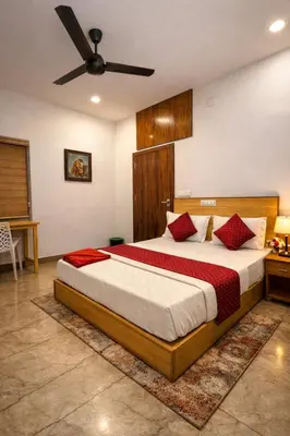 a bedroom with a bed and a ceiling fan at Grandstaykannur in Kannur