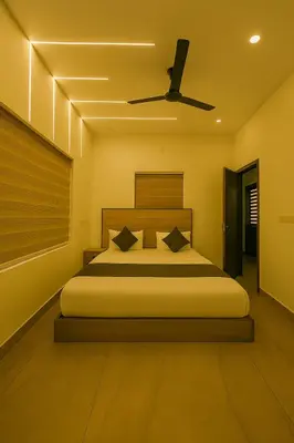 a bedroom with a bed and a ceiling fan at Grandstaykannur in Kannur